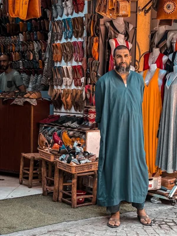 Marchand marocain en djellaba devant sa boutique de la médina